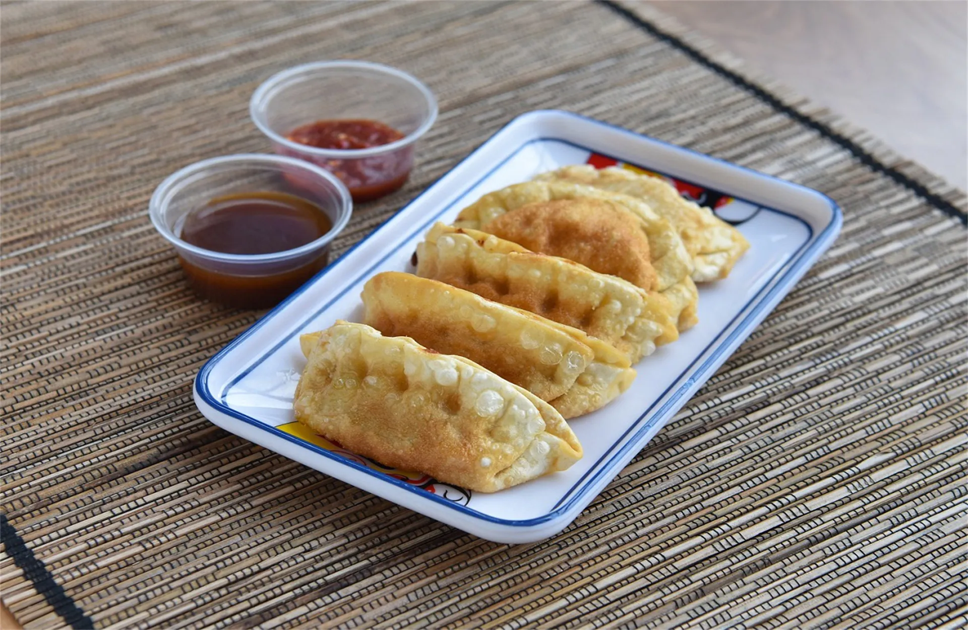 Pan-fried dumplings with dipping sauces on the side at Cooking Girl, an Chinese Restaurant in Katy