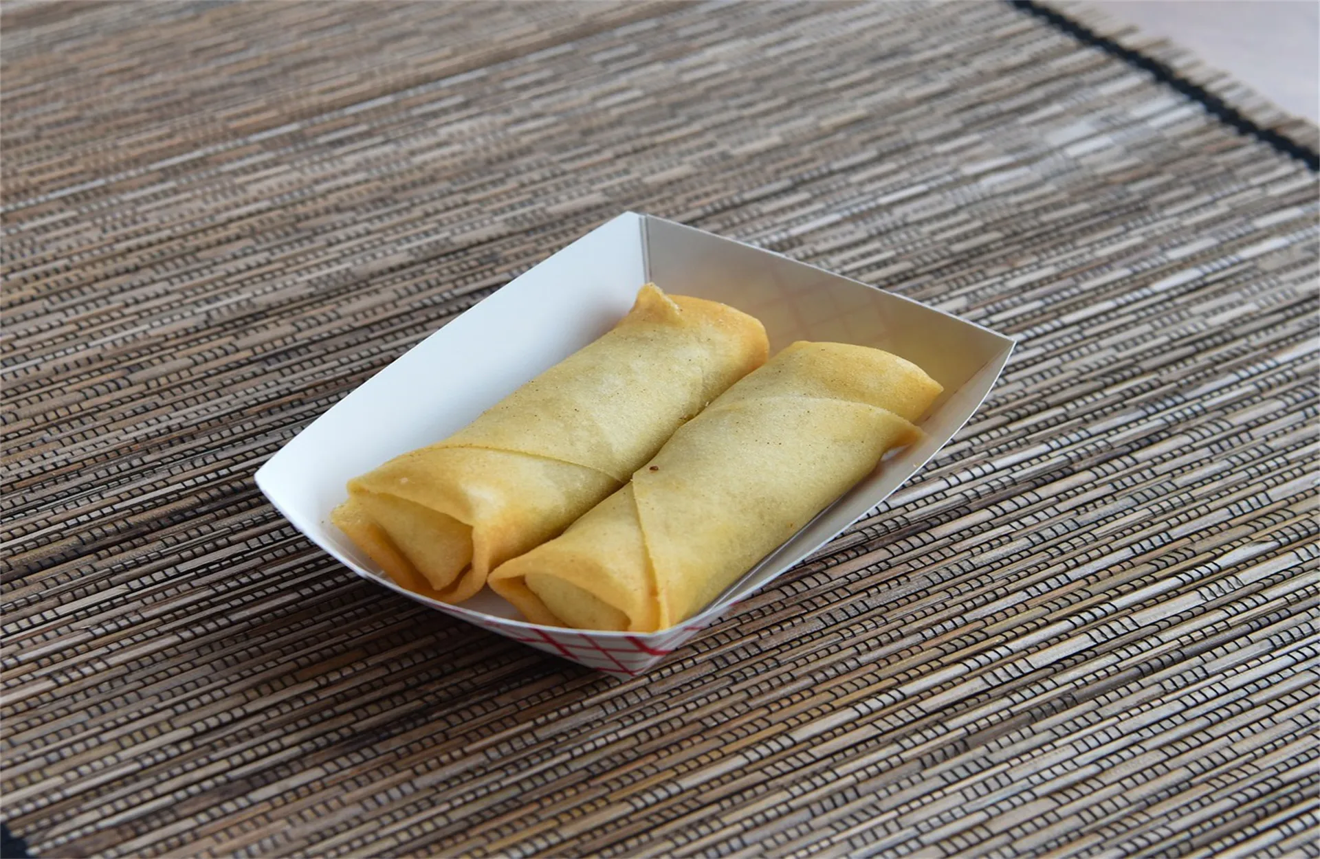 Two crispy fried spring rolls in a paper tray at Cooking Girl, an Chinese Restaurant in Katy